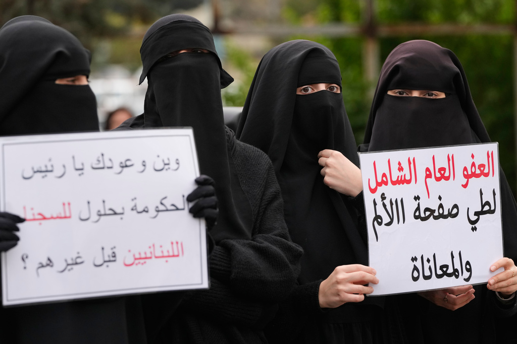 Women hold a placard reading in Arabic, "A comprehensive general amnesty to put an end to the pain and suffering," during a protest demanding a general amnesty for Islamic groups and other prisoners, in downtown Beirut, Lebanon, Friday, Jan. 30, 2026. (AP Photo/Hassan Ammar)
