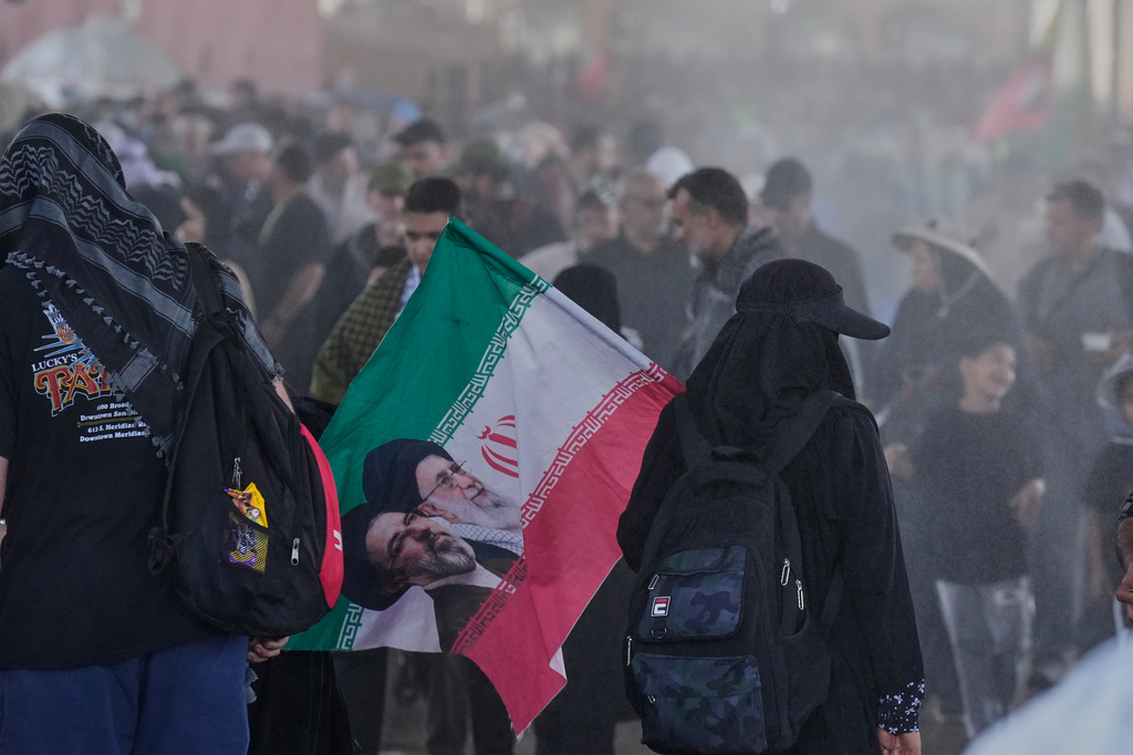 Iranian Shite pilgrims carrying Iranian flags arrive at the Al-Mundheriya border crossing to join millions of Muslims heading to the holy city of Karbala for the annual Arbaeen pilgrimage, in Diyala, Iraq, Monday, July 27, 2026. (AP Photo/Hadi Mizban)