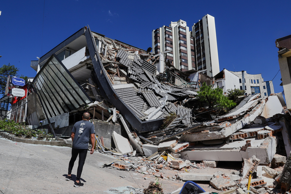 A man looks at a collapsed building after an earthquake struck Manizales, Colombia, Monday, Aug. 10, 2026. (AP Photo/Dario Cardona)
