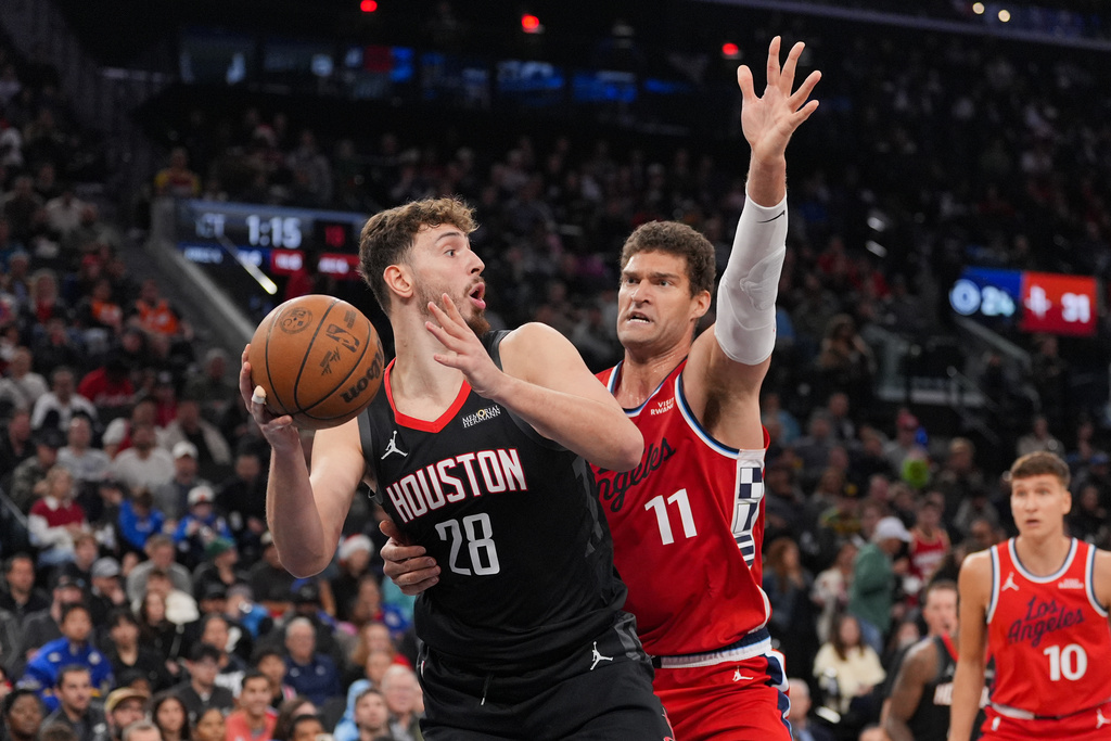 Houston Rockets center Alperen Sengun (28) looks to pass under defense by Los Angeles Clippers center Brook Lopez (11) during the first half of an NBA basketball game Tuesday, Dec. 23, 2025, in Inglewood, Calif. (AP Photo/Jae C. Hong)