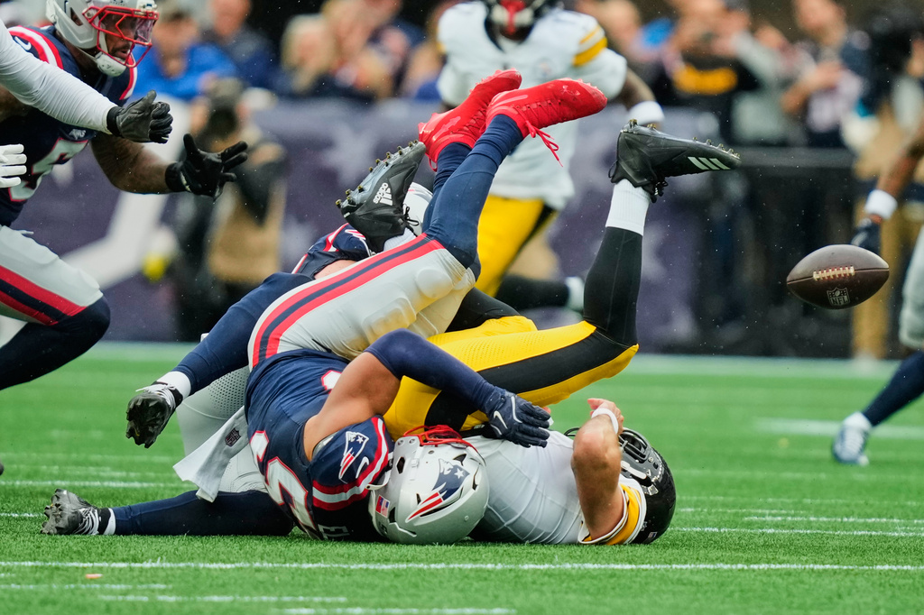 Pittsburgh Steelers quarterback Aaron Rodgers, right, is sacked by New England Patriots' Christian Elliss during the first half of an NFL football game against the New England Patriots, Sunday, Sept. 20, 2026, in Foxboro, Mass. (AP Photo/Charles Krupa)