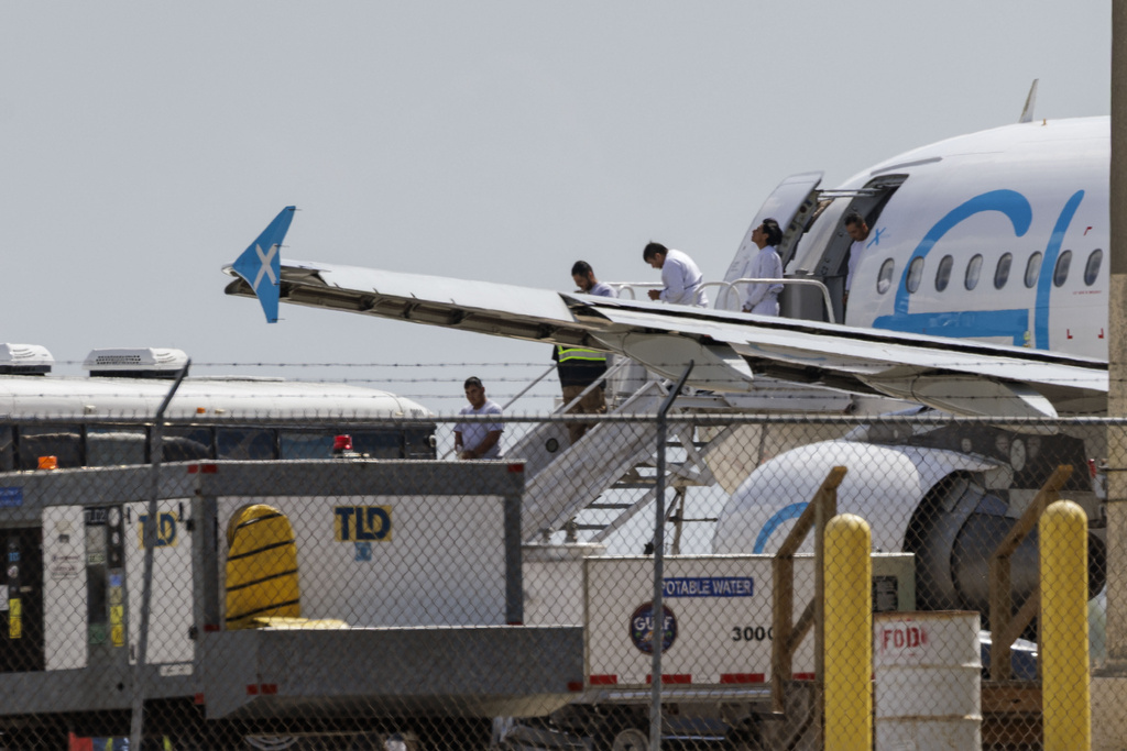 Shackled migrants deplane an aircraft used for deportation flights at the Valley International Airport, Sunday, Aug. 31, 2025, in Harlingen, Texas. (AP Photo/Michael Gonzalez)