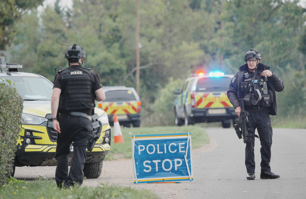 Police stand at a road block on the road to RAF Fairford after an incident, in Whelford, England, Sunday, Sept. 27, 2026 .(Ben Birchall/PA via AP)