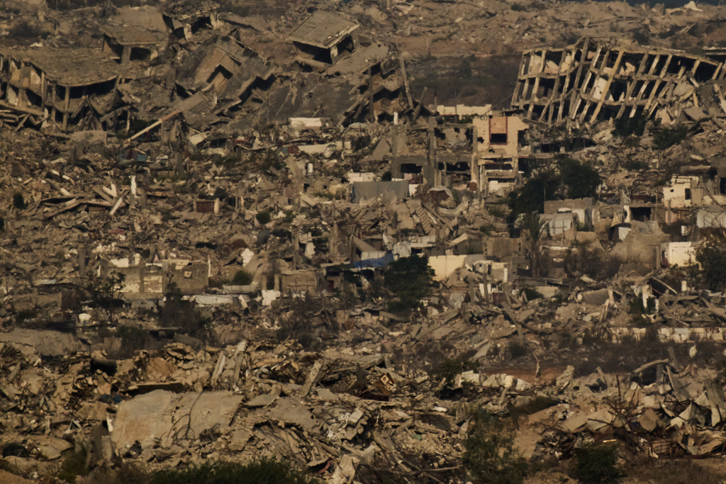 Buildings that were destroyed during the Israeli ground and air operations stand in the northern Gaza Strip during the sunrise, as seen from southern Israel, Friday, Oct. 17, 2025. (AP Photo/Leo Correa)