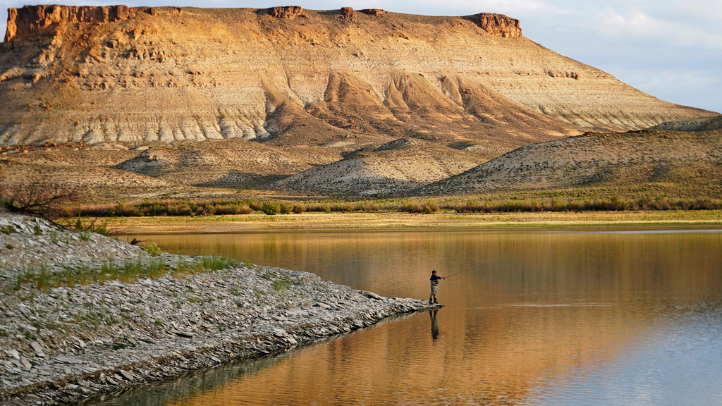 FILE - Nick Gann fishes in Firehole Canyon, Friday, Aug. 5, 2022, on the far northeastern shore of Flaming Gorge Reservoir, in Wyoming. (AP Photo/Rick Bowmer, File)