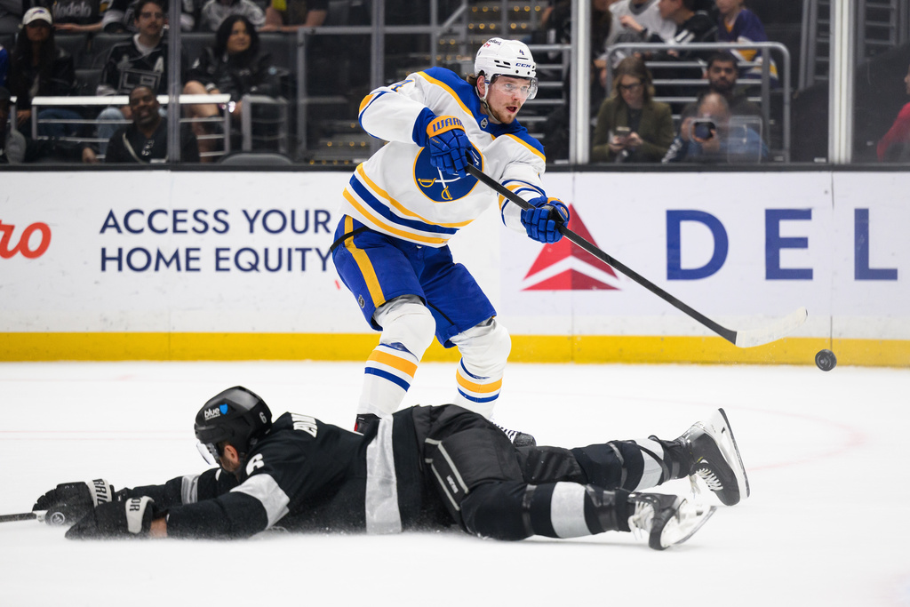 Buffalo Sabres defenseman Bowen Byram (4) shoots the puck past Los Angeles Kings defenseman Joel Edmundson (6) during the first period of an NHL hockey game Saturday, March 21, 2026, in Los Angeles. (AP Photo/William Liang)