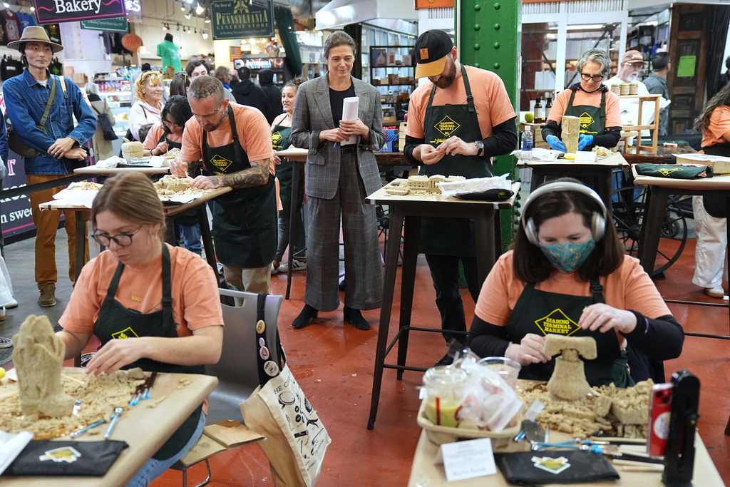 The chief executive of the Philadelphia Museum of Art, Sasha Suda, center top, walks amongst competitors in the Scrapple Sculpting Contest at the Reading Terminal Market in Philadelphia, Friday, Oct. 10, 2025. (AP Photo/Matt Rourke)