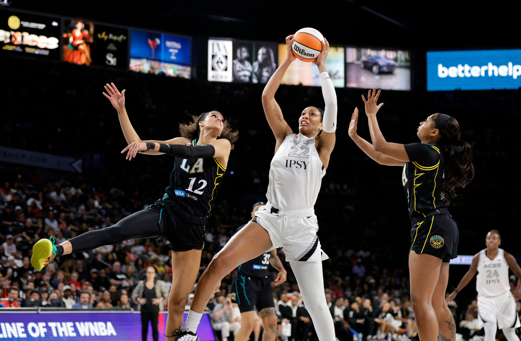 Las Vegas Aces center A'ja Wilson (22) makes a rebound between Los Angeles Sparks guards Rae Burrell (12) and Chance Gray during the first half of an WNBA basketball game Tuesday, Sept. 22, 2026, in Las Vegas. (Steve Marcus/Las Vegas Sun via AP)