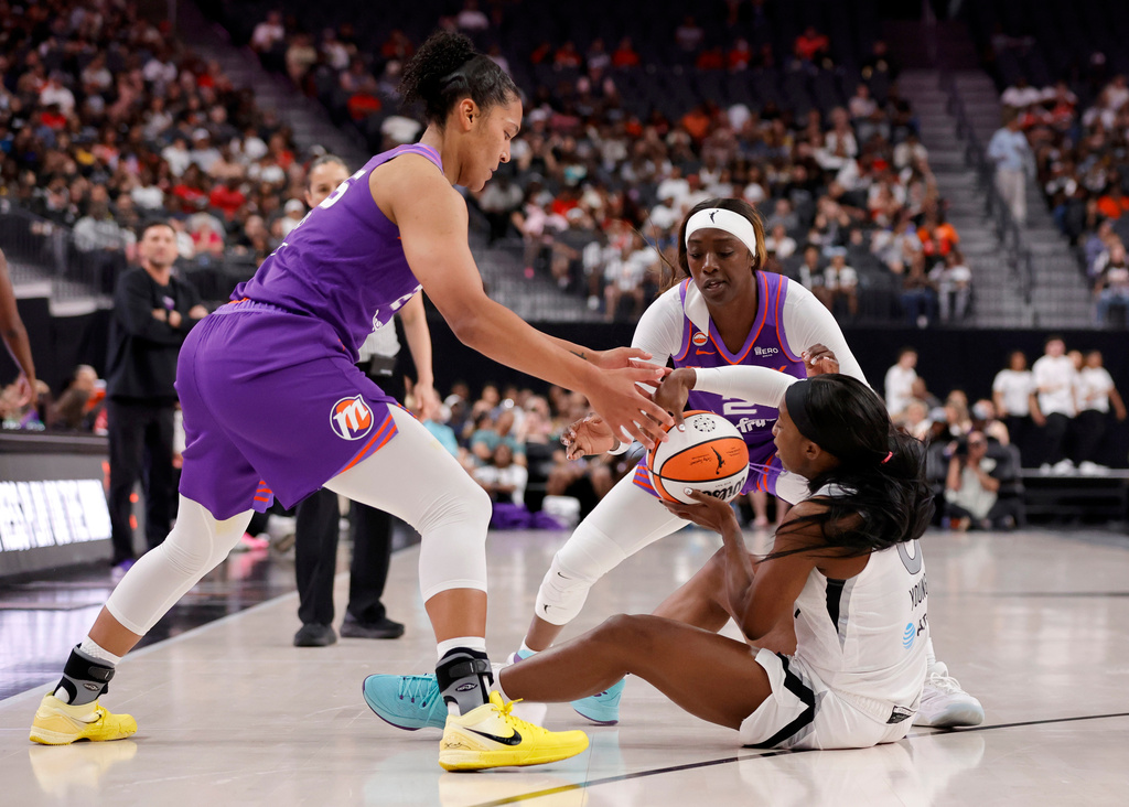 Phoenix Mercury forward Alyssa Thomas, left, and guard/forward Kahleah Copper, back right, defend against Las Vegas Aces guard Jackie Young, front right, during the first half of an WNBA basketball game Saturday, May 9, 2026, in Las Vegas. (Steve Marcus/Las Vegas Sun via AP)