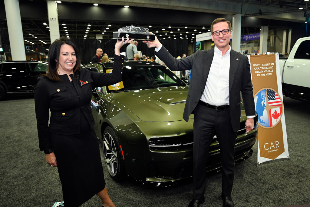 Stellantis Vice President North America Sedan Programs' Audrey Moore, left, and Dodge Brand Chief Executive Officer Stellantis North America Matt McAlear hold up the Car of The Year Award in front of the Dodge Charger, Wednesday, Jan. 14, 2026, in Detroit. (AP Photo/Jose Juarez)