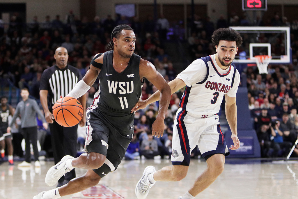 Washington State guard Jerone Morton (11) drives while pressured by Gonzaga guard Braeden Smith (3) during the first half of an NCAA college basketball game, Tuesday, Feb. 10, 2026, in Spokane, Wash. (AP Photo/Young Kwak)