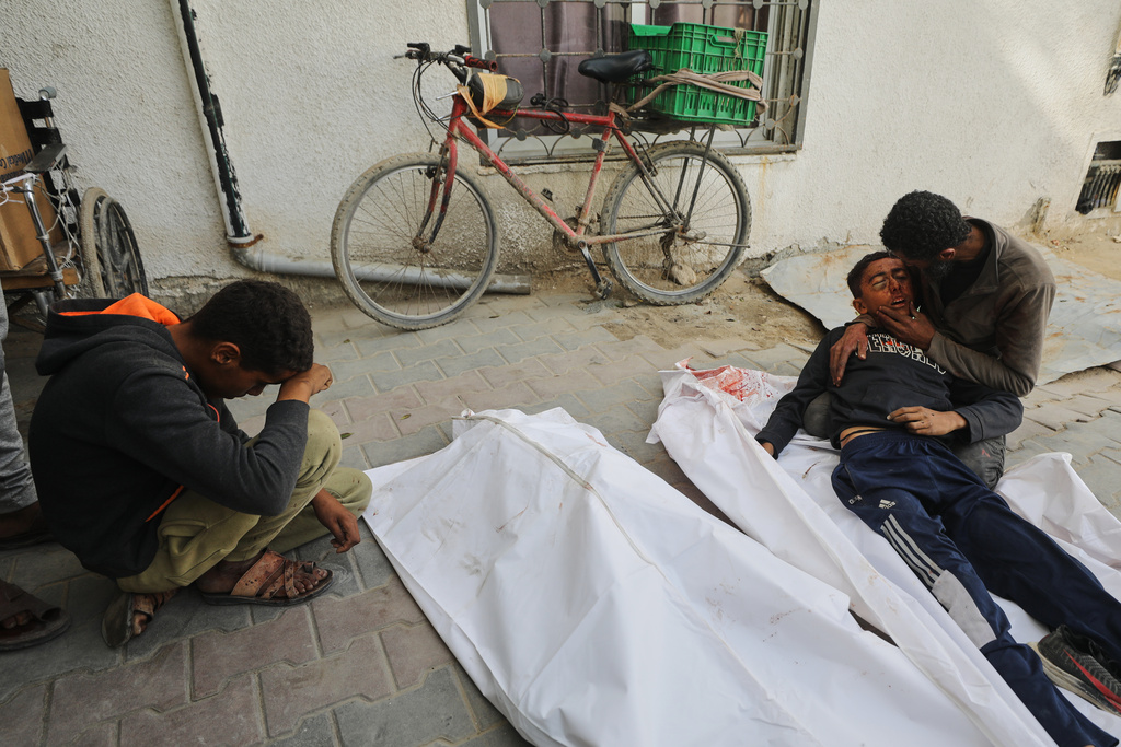 EDS NOTE: GRAPHIC CONTENT - Yusuf Zawara mourns over the body of his son, Mohammad Zawara, 15, who was killed along with his cousin Sulaiman Zawara, 13, in an Israeli strike, according to health officials, at Shifa Hospital, Gaza City, Saturday, Jan. 24, 2026. (AP Photo/Yousef Al Zanoun)