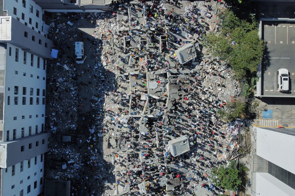 Residents and rescue workers search through the rubble after an earthquake struck Cali, Colombia, Monday, Aug. 10, 2026. (AP Photo/Santiago Saldarriaga)