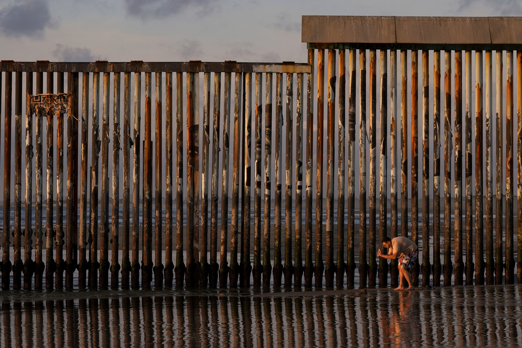 FILE - A man takes an image with his phone next to where the border wall separating Mexico and the United States reaches the Pacific Ocean Jan. 28, 2025, in Tijuana, Mexico. (AP Photo/Gregory Bull, File)