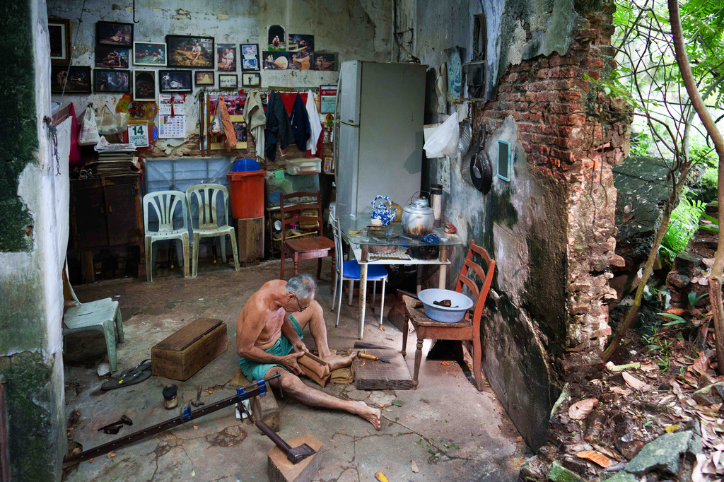 Traditional Chinese coffin maker Goh Khuay Par uses a hand tool to shape a miniature coffin at his workshop in Muar, Malaysia, Tuesday, July 14, 2026. (AP Photo/Vincent Thian)