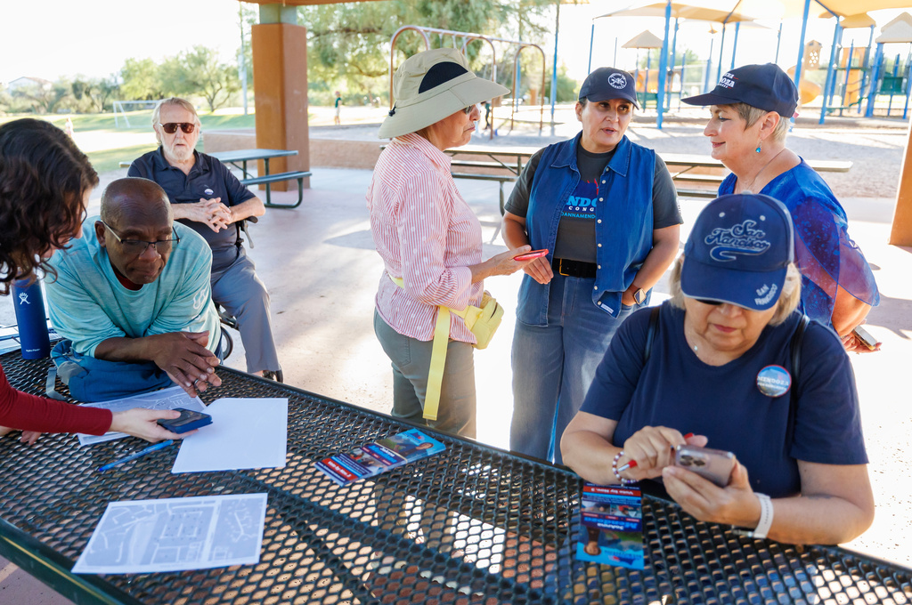 JoAnna Mendoza (D), standing second from right, an Arizona Congressional District 6 candidate, talks with campaign volunteers before a weekly neighborhood canvass, Thursday, Oct. 15, 2026, in Oro Valley, Ariz. (AP Photo/Mike Christy)