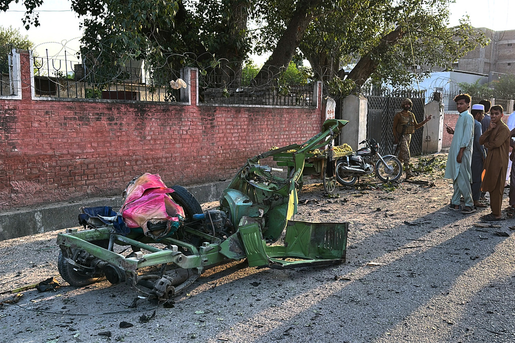 An army soldier and local residents look the wreckage of auto rickshaw on the site of a powerful bomb exploded at a mosque in Kohat, in northwestern Pakistan, Friday, Sept. 18, 2026. (AP Photo/Maaz Awan)