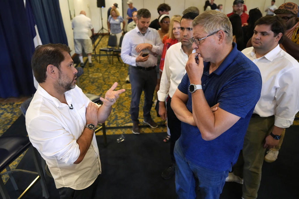 Sen. Ruben Gallego, D-Ariz., talks with Mike Pace, right, of Bettendorf, Iowa, during a town hall meeting, Saturday, Aug. 9, 2025, in Davenport, Iowa. (AP Photo/Charlie Neibergall)