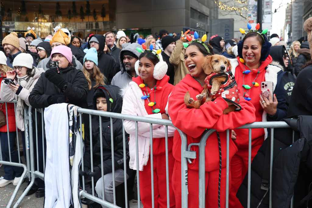 Spectators watch as the Macy's Thanksgiving Day Parade passes them, Thursday, Nov. 27, 2025, in New York. (AP Photo/Heather Khalifa)