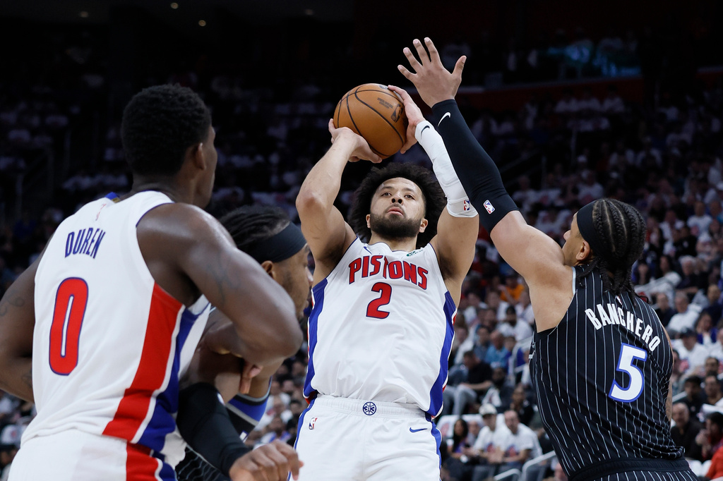 Detroit Pistons guard Cade Cunningham (2) takes a shot against Orlando Magic forward Paolo Banchero (5) as Pistons center Jalen Duren (0) helps defend during the first half in Game 2 of a first-round NBA basketball playoffs series Wednesday, April 22, 2026, in Detroit. (AP Photo/Duane Burleson)