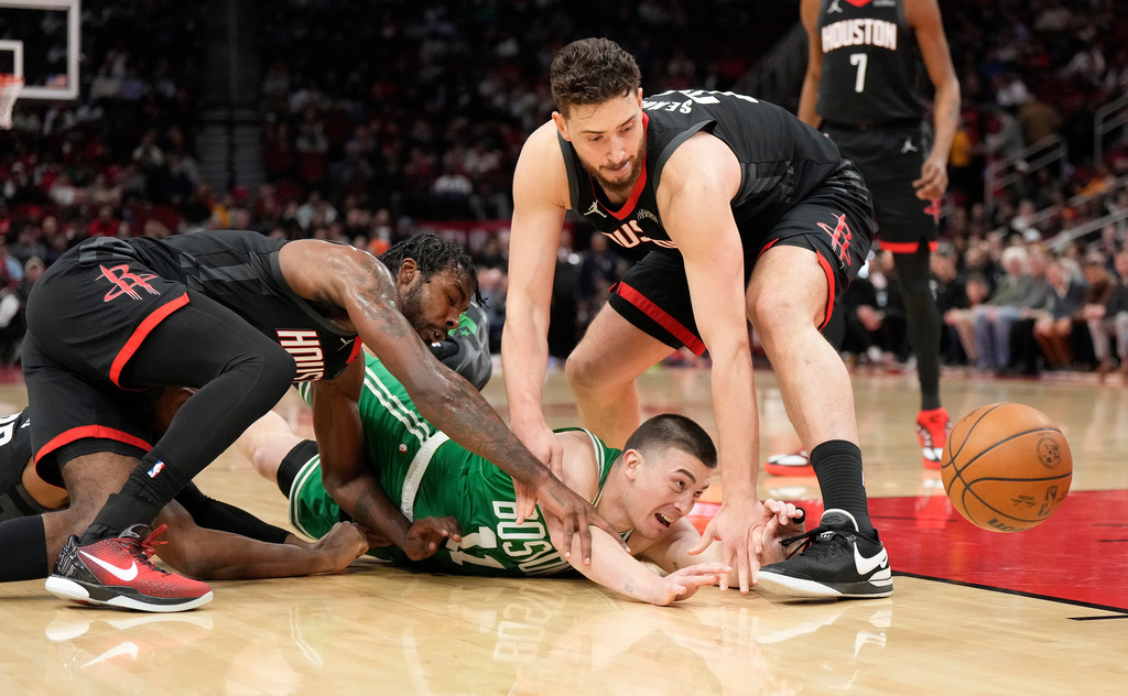 Boston Celtics guard Payton Pritchard loses control of the ball against Houston Rockets' Tari Eason, left, and Alperen Sengun, right, during the first half of an NBA basketball game, in Houston, Wednesday, Feb. 4, 2026. (AP Photo/ Karen Warren)
