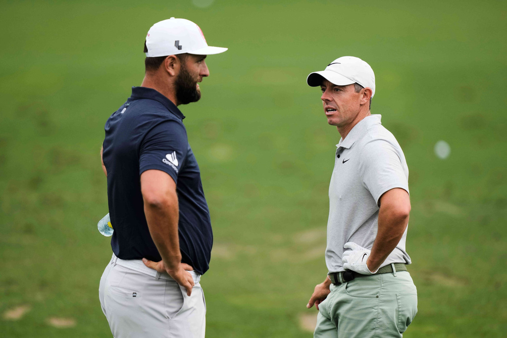 FILE - Jon Rahm, left, of Spain, talks with Rory McIlroy, of Northern Ireland, on the practice range during a practice round in preparation for the Masters golf tournament at Augusta National Golf Club Tuesday, April 9, 2024, in Augusta, Ga. (AP Photo/Charlie Riedel, File)