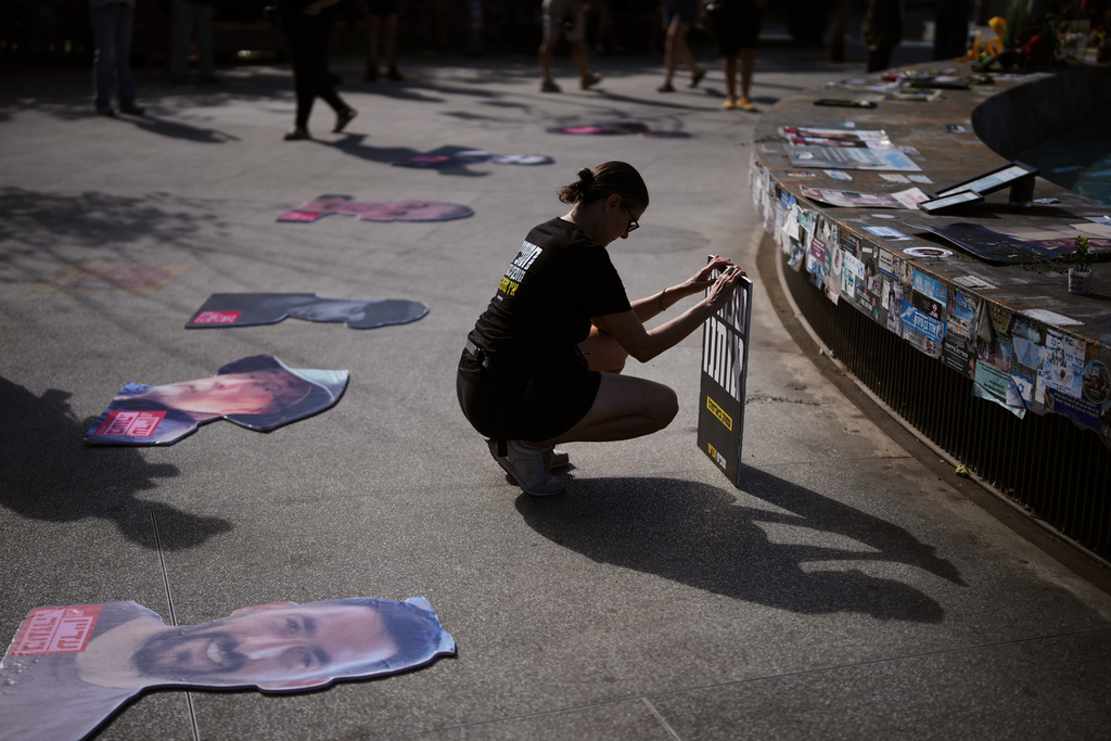 People gather at a memorial marking the two year anniversary of the deadly Hamas attack on Israel, calling for the release of all hostages held by Hamas in the Gaza Strip and an end to the war, in Tel Aviv, Israel, Tuesday, Oct. 7, 2025. (AP Photo/Emilio Morenatti)