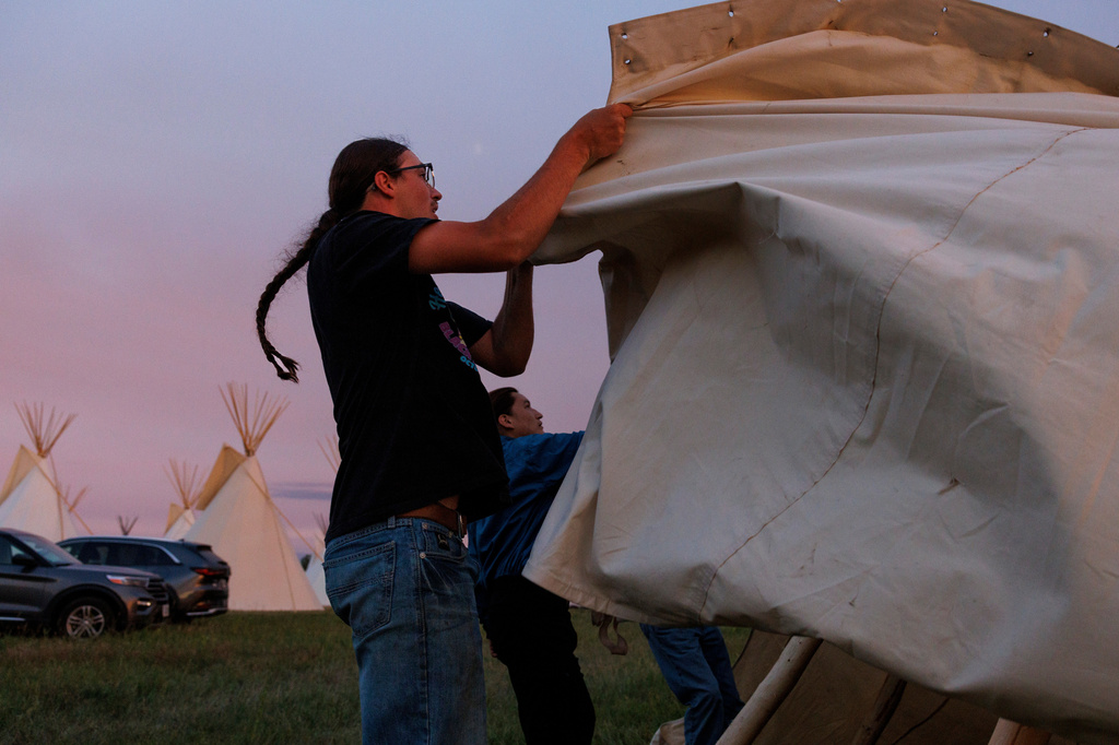 Dawson Richards helps his father set up a tipi during festivities commemorating the 150th anniversary of the Battle of the Little Bighorn, Wednesday, June 24, 2026, in Crow Agency, Mont. (AP Photo/Tailyr Irvine)