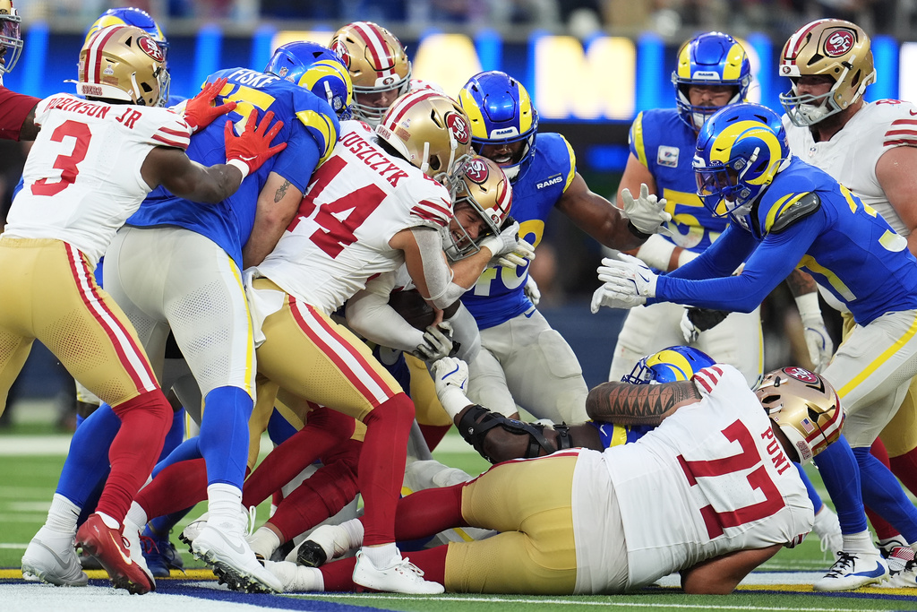 San Francisco 49ers quarterback Mac Jones, middle, runs for a first down during the first half of an NFL football game against the Los Angeles Rams, Thursday, Oct. 2, 2025, in Inglewood, Calif. (AP Photo/Marcio Jose Sanchez)