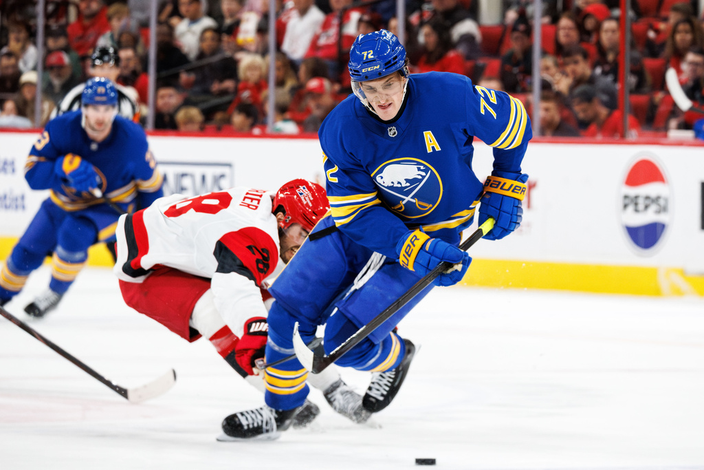 Buffalo Sabres Tage Thompson handles the puck ahead of Carolina Hurricanes William Carrier during the first period of an NHL hockey game in Raleigh, N.C., Saturday, Nov. 8, 2025. (AP Photo/Ben McKeown)