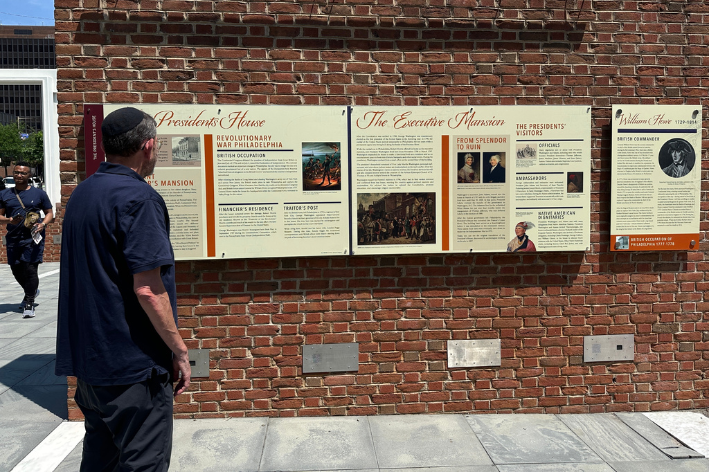 Visitors view the reinstalled educational panels about slavery at the site of President George Washington's home in Philadelphia, Wednesday, July 15, 2026. (AP Photo/Tassanee Vejpongsa)