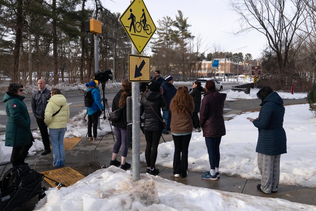 People wait outside Thomas S. Wootton High School for students in Rockville Md., Monday, Feb. 9, 2026, after a person was shot inside the school. (AP Photo/Jose Luis Magana)