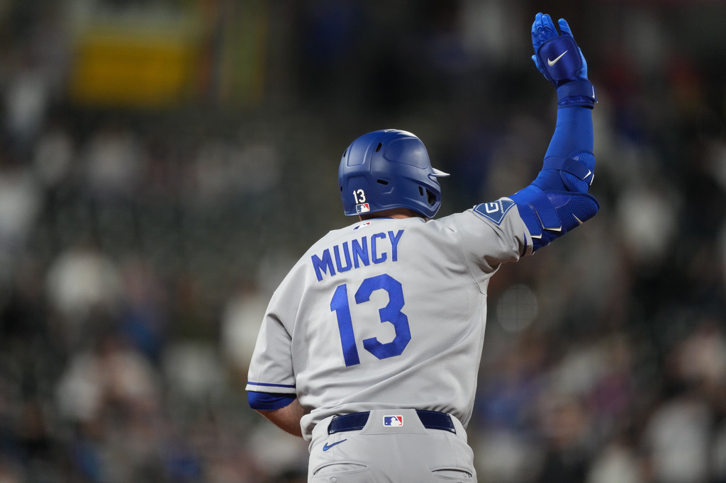 Los Angeles Dodgers' Max Muncy waves to the bullpen as he circles the bases after hitting a solo home run off Colorado Rockies relief pitcher Tanner Gordon in the ninth inning of a baseball game Monday, April 20, 2026, in Denver. (AP Photo/David Zalubowski)