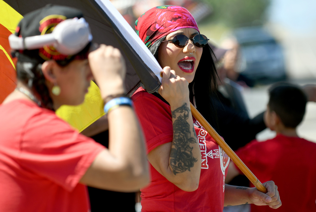 Danelle Kawasaki, a spokeswoman for the Montana American Indian Movement, protests near the Foundations for Nations church in Arapahoe, Wyo., on Sunday, Aug. 16, 2026. (AP Photo/Thomas Peipert)