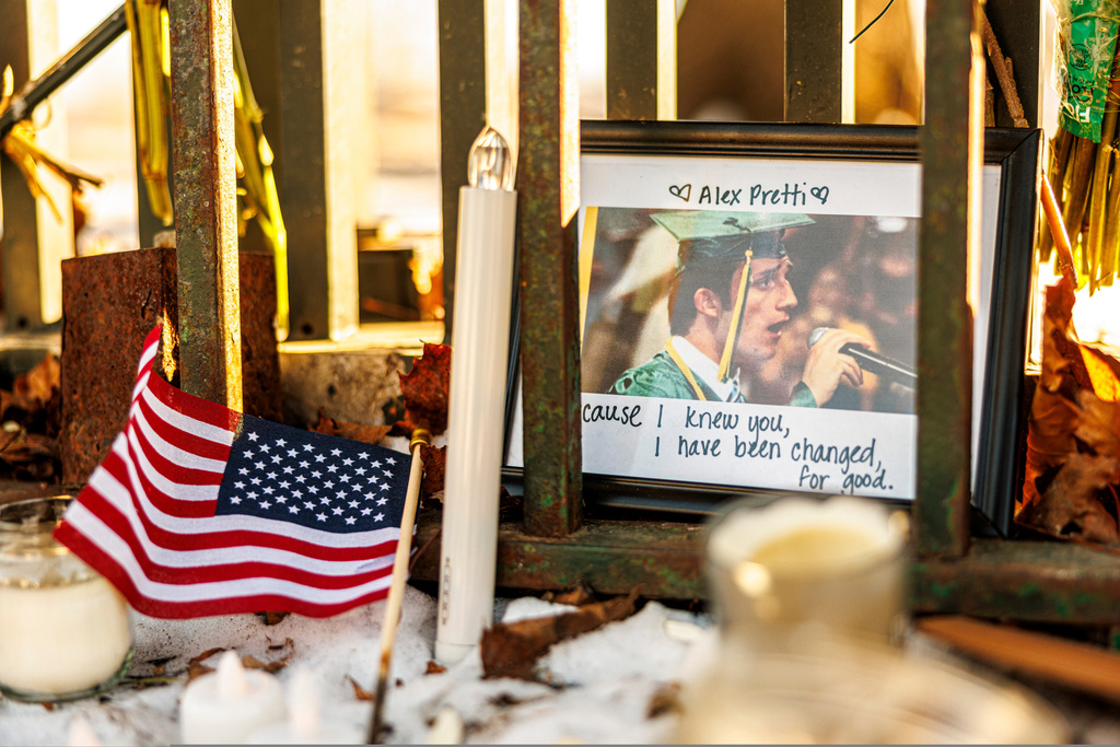 A framed photograph of Alex Pretti, along with candles and an American flag, sits at a memorial outside the Minneapolis VA hospital on Tuesday, Jan. 27, 2026, in Minneapolis. (Kerem Yücel/Minnesota Public Radio via AP)
