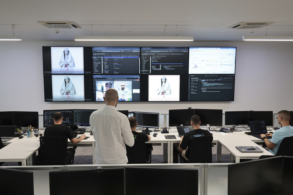 Albanian experts work at the National Agency for Information Society as an artificial intelligence "minister" Diella, whose name means "Sun" in Albanian, is seen on the screens in Tirana, Albania, Friday, Sept. 12, 2025. (AP Photo/Vlasov Sulaj)