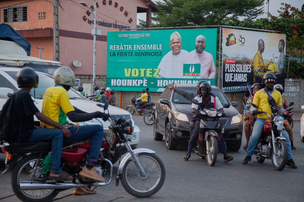 Road users pass in front of a campaign billboard for presidential candidate Paul Hounkpe and his running mate, Rock Hounwanou in Cotonou, Benin, Friday, April 10, 2026. (AP Photo/Abadjaye Justin Sodogandji)