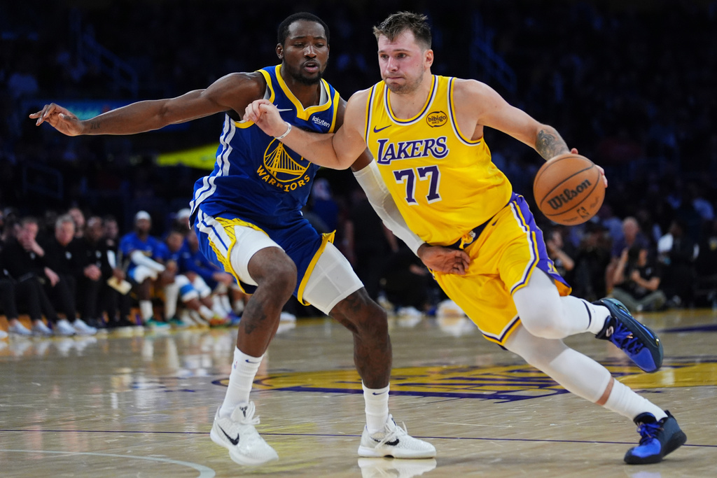 Los Angeles Lakers guard Luka Doncic (77) drives the ball against the Golden State Warriors during the second half of an NBA basketball game Tuesday, Oct. 21, 2025, in Los Angeles. (AP Photo/Ethan Swope)