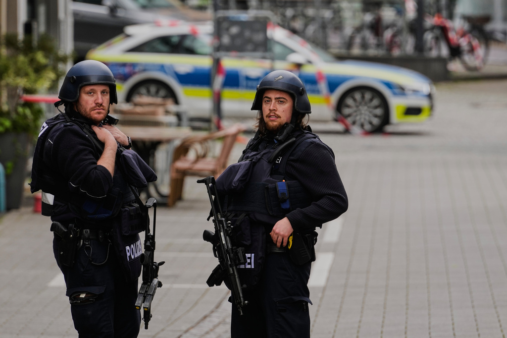 Police officers stand at the scene of a hostage-taking at a bank branch in Sinzig, Germany, Friday, May 8, 2026. (AP Photo/Michael Probst)