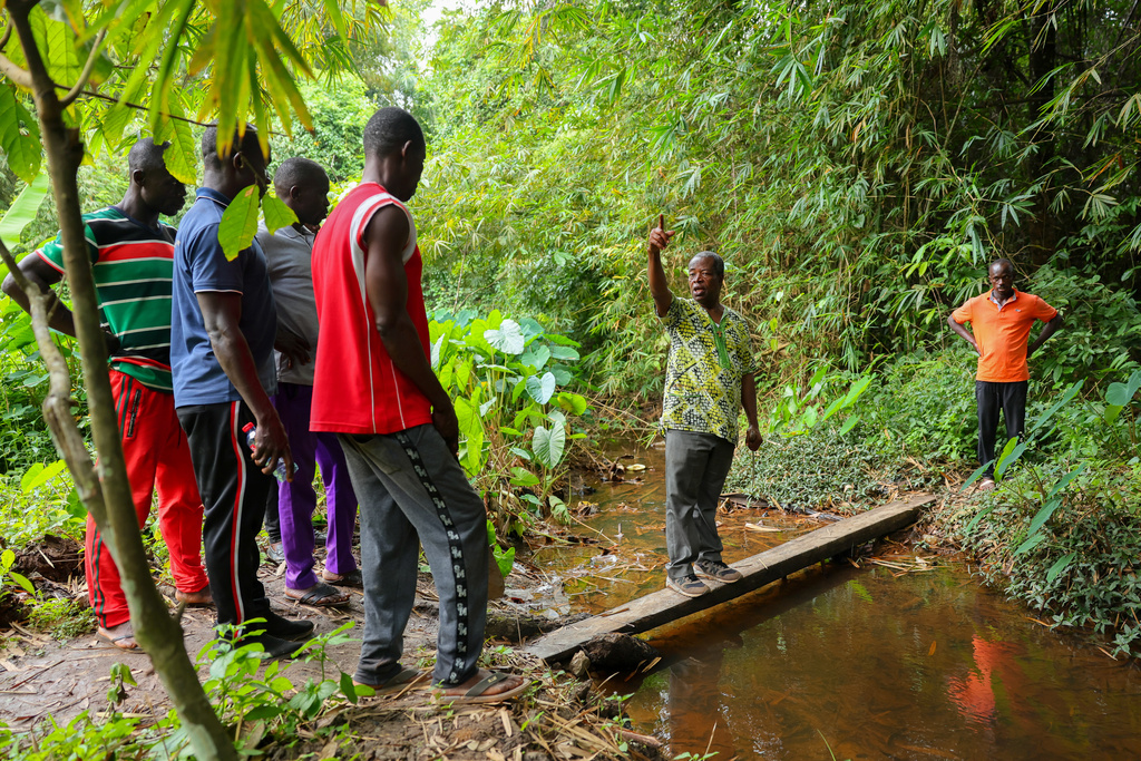 Friar Joseph Kwame Blay, center, a Ghanaian Franciscan Catholic Pries and native of Jema, and members of a local anti-illegal gold mining task force patrol a forest reserve in the Jema community in the Western North Region, Ghana, Thursday, Sept. 11, 2025. (AP Photo/Tsraha Yaw)