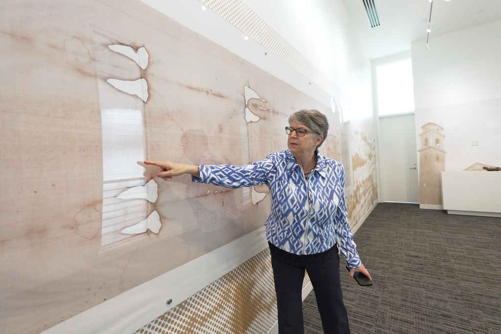 Nora Creech, director of Othonia North America, points to a replica of the Shroud of Turin at a new interactive museum dedicated to the shroud, Monday, Nov. 17, 2025, at the Christ Cathedral campus in Garden Grove, Calif. (AP Photo/Krysta Fauria)