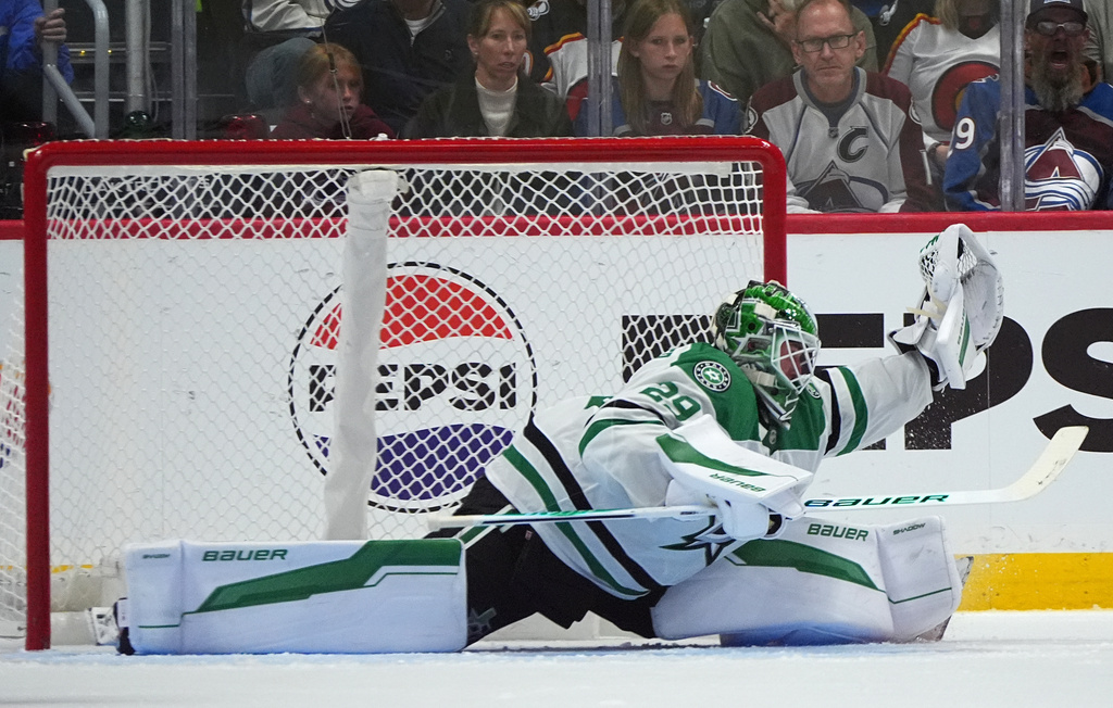 Dallas Stars goaltender Jake Oettinger makes a glove save in overtime of an NHL hockey game against the Colorado Avalanche Saturday, Oct. 11, 2025, in Denver. (AP Photo/David Zalubowski)