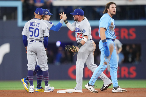 Los Angeles Dodgers second baseman Miguel Rojas (72) celebrates with shortstop Mookie Betts (50) and left fielder Enrique Hernández (8) after forcing out Toronto Blue Jays' Addison Barger (47) to end the game during ninth inning Game 6 World Series playoff MLB baseball action in Toronto on Friday, Oct. 31, 2025. (Nathan Denette/The Canadian Press via AP) Los Angeles Dodgers second baseman Miguel Rojas (72) celebrates with shortstop Mookie Betts (50) and left fielder Enrique Hernández (8) after forcing out Toronto Blue Jays' Addison Barger (47) to end the game during ninth inning Game 6 World Series playoff MLB baseball action in Toronto on Friday, Oct. 31, 2025. (Nathan Denette/The Canadian Press via AP)