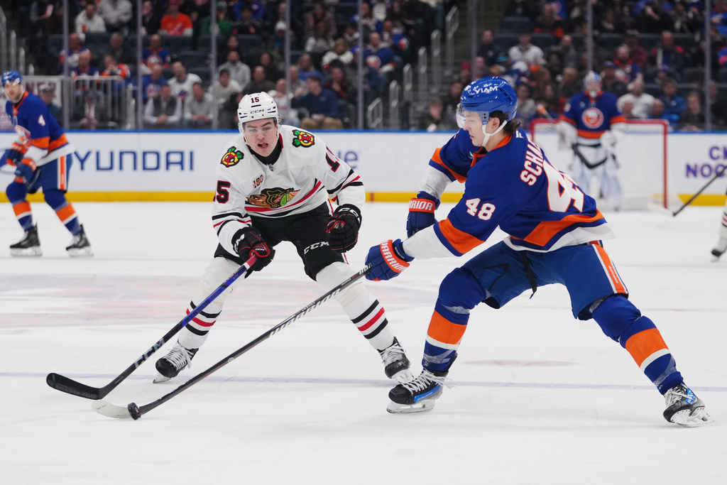 Chicago Blackhawks' Anton Frondell (15) fights for control of the puck with New York Islanders' Matthew Schaefer (48) during the second period of an NHL hockey game Tuesday, March 24, 2026, in Elmont, N.Y. (AP Photo/Frank Franklin II)