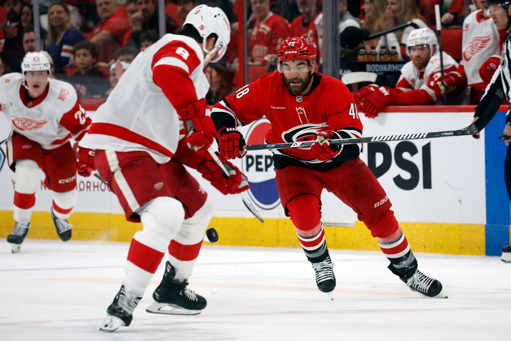 Carolina Hurricanes' Jordan Martinook (48) chases the puck toward Detroit Red Wings' Ben Chiarot (8) during the second period of an NHL hockey game in Raleigh, N.C., Saturday, Feb. 28, 2026. (AP Photo/Karl DeBlaker)