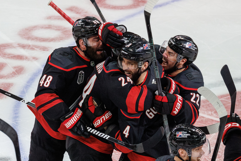 Carolina Hurricanes' Jordan Martinook (48), Seth Jarvis (24), Shayne Gostisbehere (4), and Logan Stankoven (22) ceelbrate after Jarvis scored the game-winning goal against against the Vegas Golden Knights in overtime of Game 2 of the NHL hockey Stanley Cup Final series in Raleigh, N.C., Thursday, June 4, 2026. (AP Photo/Ben McKeown)