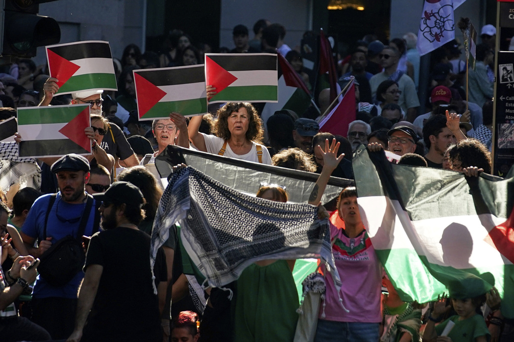 People shout slogans and hold Palestinian flags while protesting during the twenty-first stage of La Vuelta cycling race from Alalpardo to Madrid, Spain, Sunday, Sept. 14, 2025. (AP Photo/Andrea Comas)