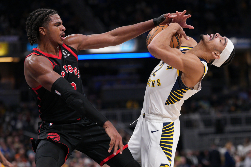 Indiana Pacers guard Andrew Nembhard, right, is fouled by Toronto Raptors forward Collin Murray-Boyles during the first half of an NBA basketball game in Indianapolis, Wednesday, Jan. 14, 2026. (AP Photo/AJ Mast)