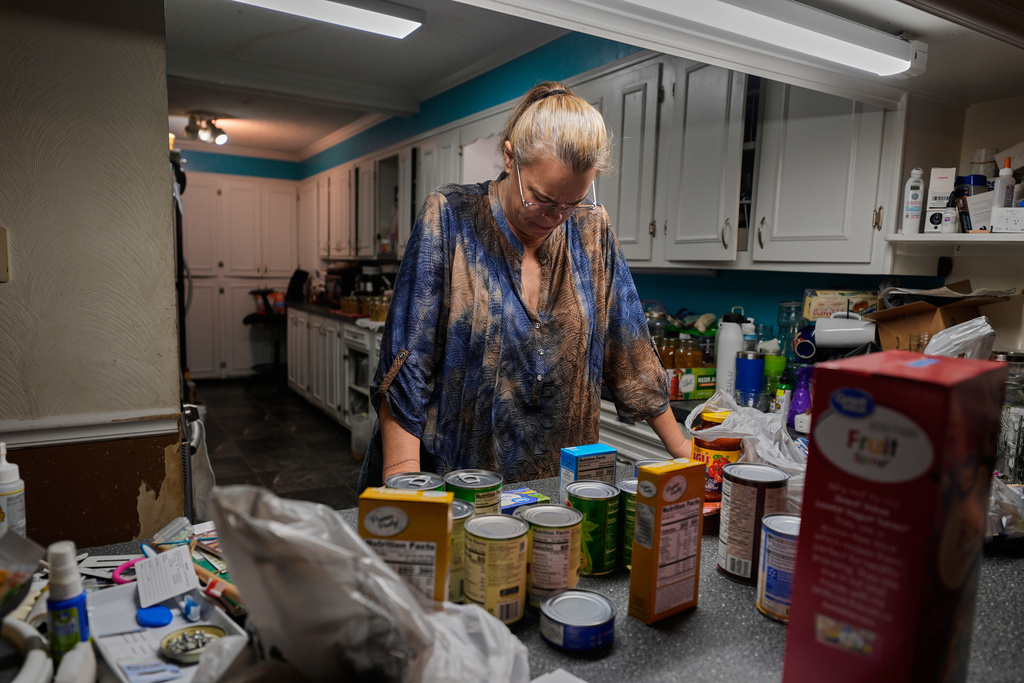 CORRECTS GOLDIE"S FIRST NAME - Goldie Getter, the wife of a civil service employee who was furloughed due to the government shutdown, unpacks groceries her husband received from a food bank, in Gulfport, Miss., Monday, Nov. 3, 2025. (AP Photo/Gerald Herbert)