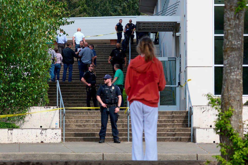 A student watches as Tacoma Police officers investigate after multiple people were injured in a stabbing at Foss High School, Thursday, April 30, 2026, in Tacoma, Wash. (AP Photo/John Froschauer)